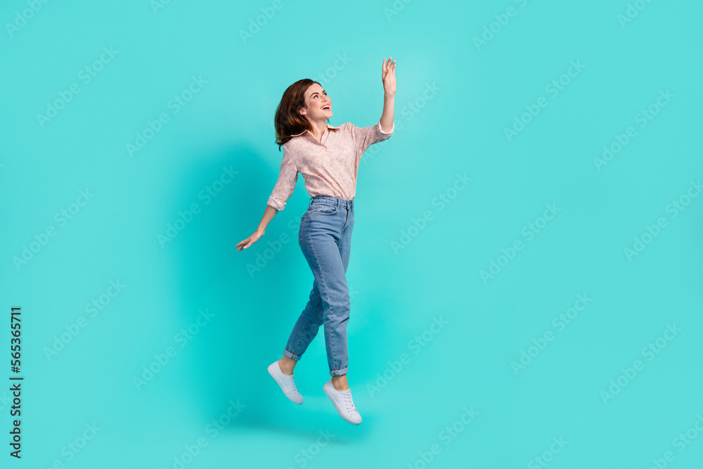 Full length photo of sweet dreamy girl dressed pink shirt waving arm walking jumping high isolated teal color background Full length photo of sweet dreamy girl dressed pink shirt waving arm walking jumping high isolated teal color background