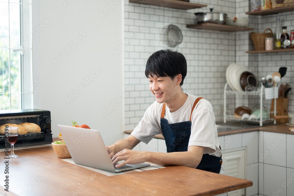 Young man learning to cook while watching tutorials in internet.. Young man learning to cook while watching tutorials in internet..