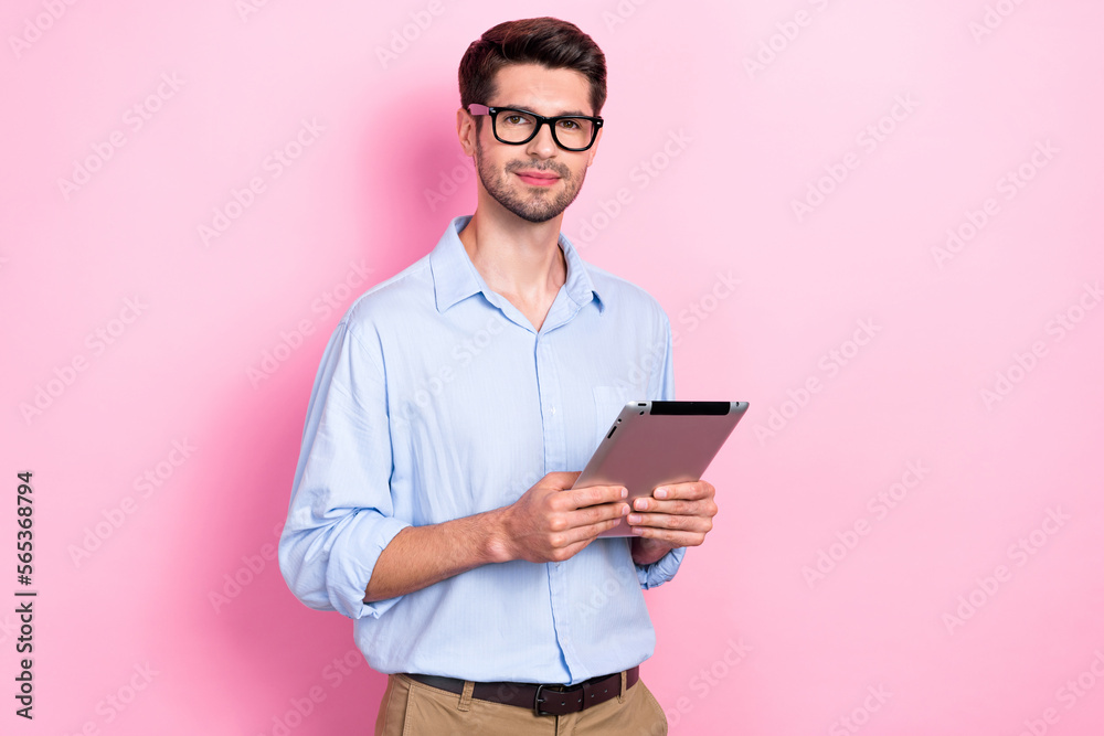 Photo of young successful entrepreneur brunet hair handsome man hold new tablet gadget use for browsing information isolated on pink color background Photo of young successful entrepreneur brunet hair handsome man hold new tablet gadget use for browsing information isolated on pink color background