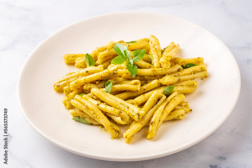 Casarecce pasta with cilantro pesto sauce on a grey background, top view. Delicious vegetarian lunch. Casarecce pasta with cilantro pesto sauce on a grey background, top view. Delicious vegetarian lunch.