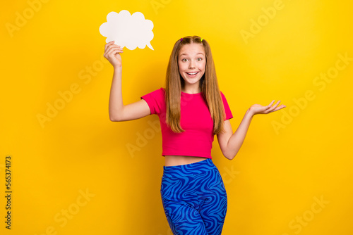 Photo of funny teenager girl wearing vintage blue leggings stylish crop top no idea shrug shoulders cloud think isolated on yellow color background photo