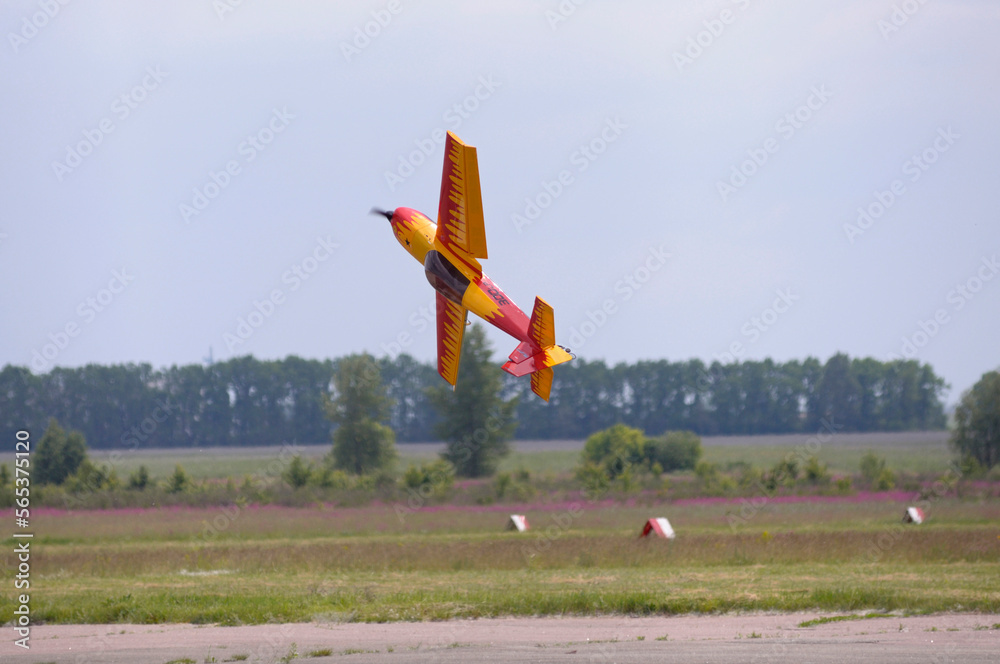 Radio controlled plane flying in the sky performing aerobatics - obrazy, fototapety, plakaty 