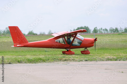 Light sport plane landed on the landing field, silhouette of a pilot sitting in a cockpit