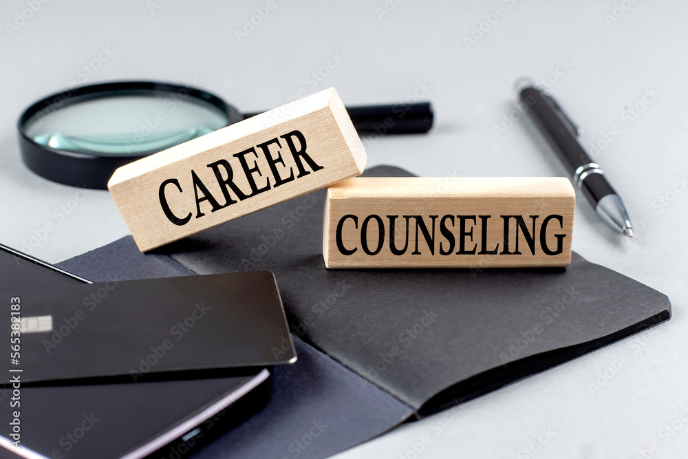 Fototapeta premium CAREER COUNSELING text on wooden block on black notebook , business concept