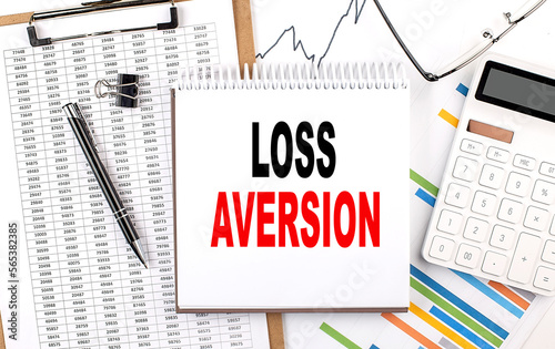 LOSS AVERSION text on notebook with chart, calculator and pen