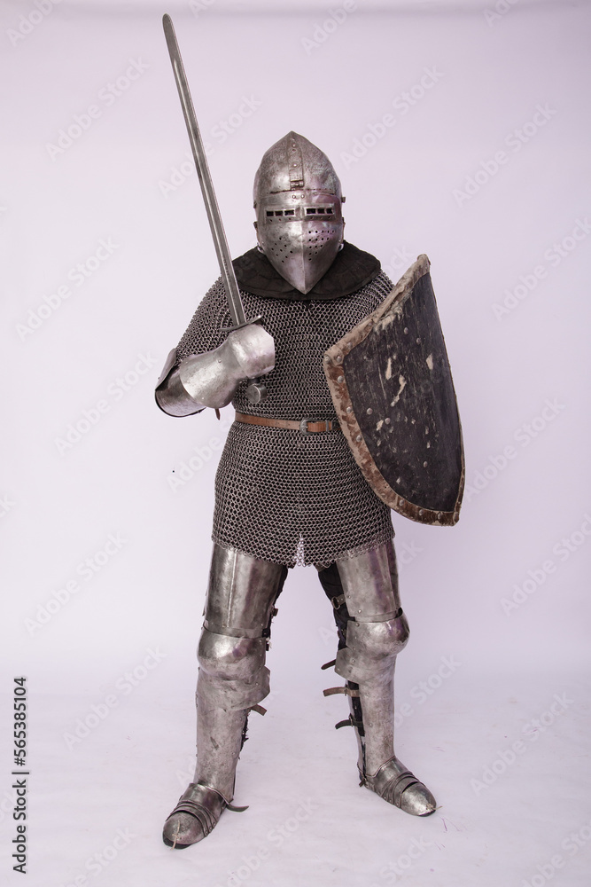 Romantic knight in armor with sword and helmet. Warrior in chain mail on a white background.
