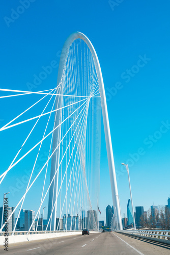 Margaret Hunt Hill Bridge with the clean blue sky and Dallas City downtown skyline on the background, cityscape from the highway over the Trinity River in Texas, USA