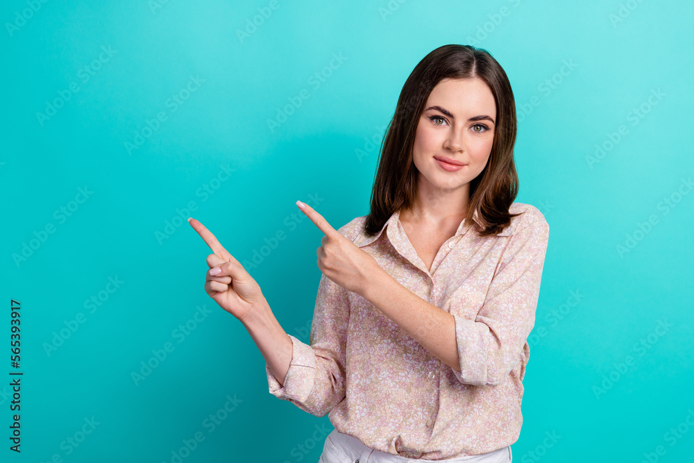 Photo portrait of stunning young lady point copyspace banner dressed stylish smart casual clothes isolated on aquamarine color background