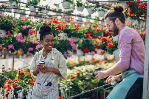 Multiracial florists working in a green house plant nursery and drinking coffee © Zamrznuti tonovi