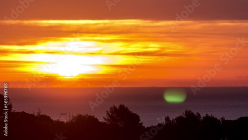 Time lapse of the sunrise over the Mediterranean sea, sharp sun with clouds, french riviera cote azur, Antibes, 4K photo