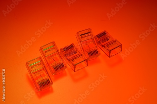 Connector rg 45 for internet cable. Several connectors lie on a multi-colored background. Close-up photo