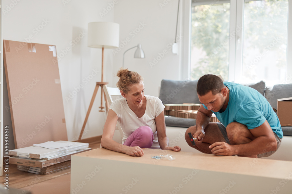 Husband and wife assembling new furniture - home renovation concept. Husband and wife assembling new furniture - home renovation concept.
