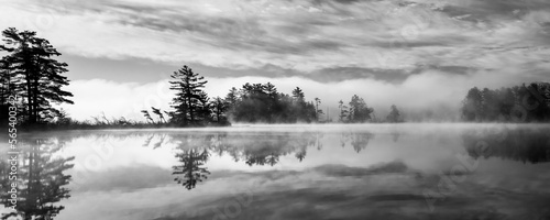 Mist and fog and clouds mix together to create a surreal sunrise scene on a Northwoods lake. Oneida County, WI.