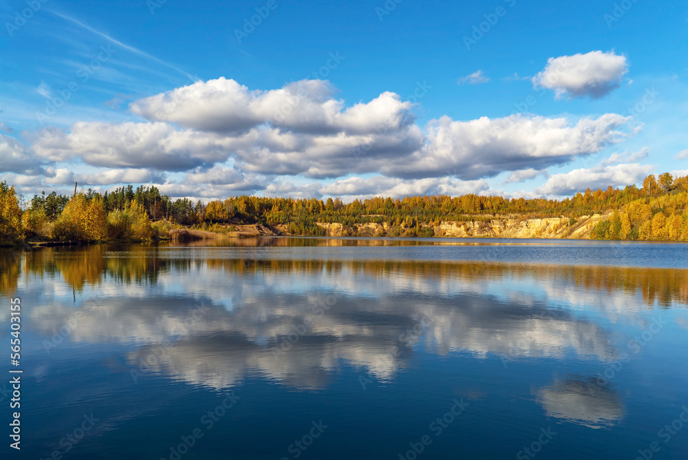 Snow-white clouds are reflected in the lake in autumn.