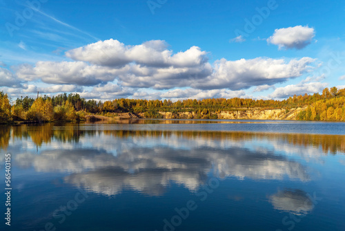 Snow-white clouds are reflected in the lake in autumn.
