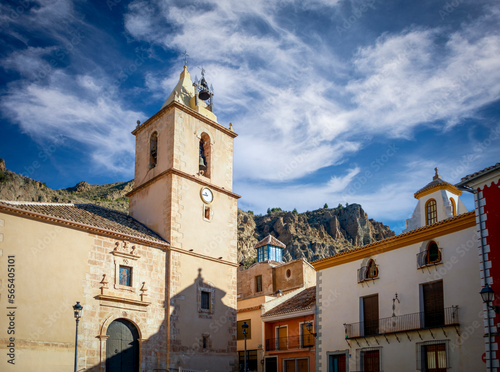 Town square in Blanca, Murcia, Spain, with the church and some unique palaces with the mountains in the background