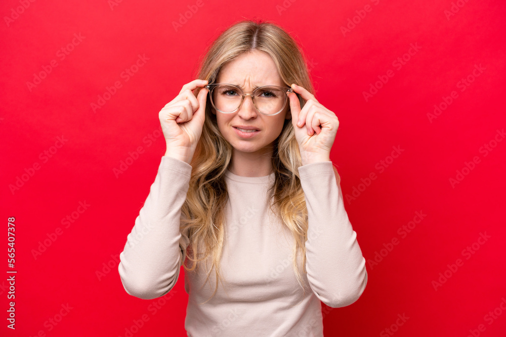 Young English woman isolated on red background With glasses and frustrated expression Young English woman isolated on red background With glasses and frustrated expression