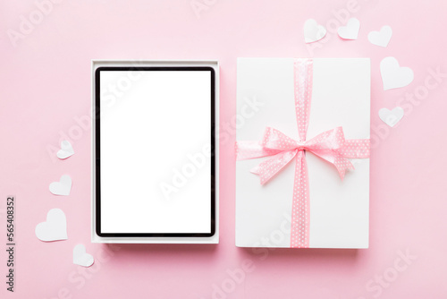 Gift box of open tablet for the holidays with a bow top view