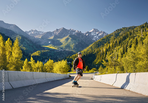 Skater traveling in the mountains on his longboard © pikoso.kz