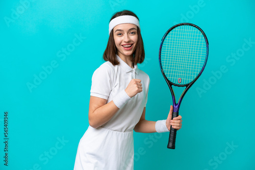 Young Ukrainian woman isolated on blue background playing tennis and celebrating a victory © luismolinero
