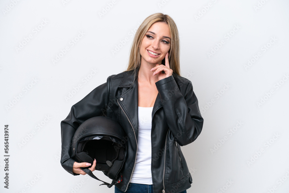 Pretty blonde woman with a motorcycle helmet isolated on white background thinking an idea while looking up Pretty blonde woman with a motorcycle helmet isolated on white background thinking an idea while looking up