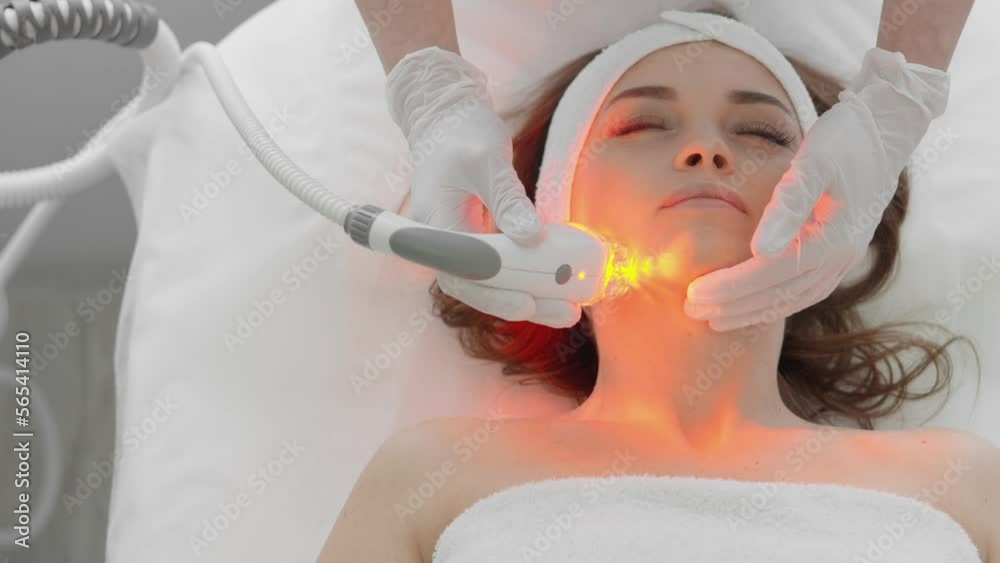 Red LED treatment. Woman doing facial skin therapy. Radiofrequency face lifting. Hardware antiaging procedure. RF lifting and vacuum massage. A cosmetologist performs a cosmetology procedure Red LED treatment. Woman doing facial skin therapy. Radiofrequency face lifting. Hardware antiaging procedure. RF lifting and vacuum massage. A cosmetologist performs a cosmetology procedure
