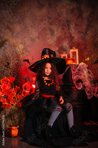 Little girl in a witch's hat and black dress on the background of the cobwebs. Image for Halloween. Halloween costume © Вероника Преображенс