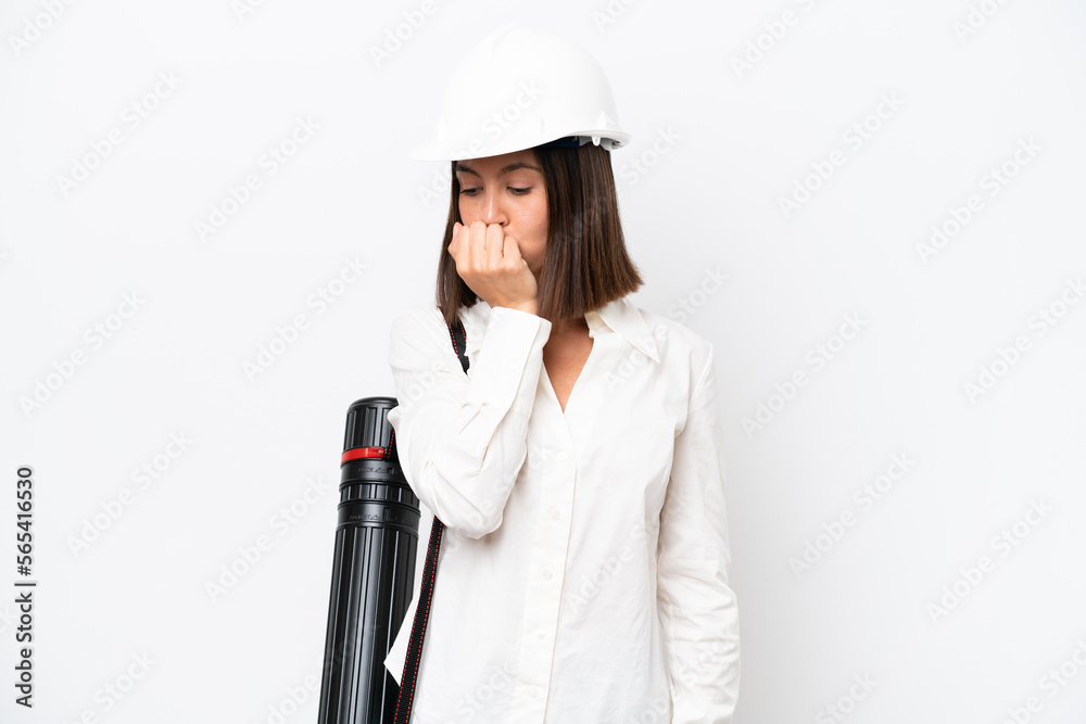 Young architect woman with helmet and holding blueprints isolated on white background having doubts Young architect woman with helmet and holding blueprints isolated on white background having doubts