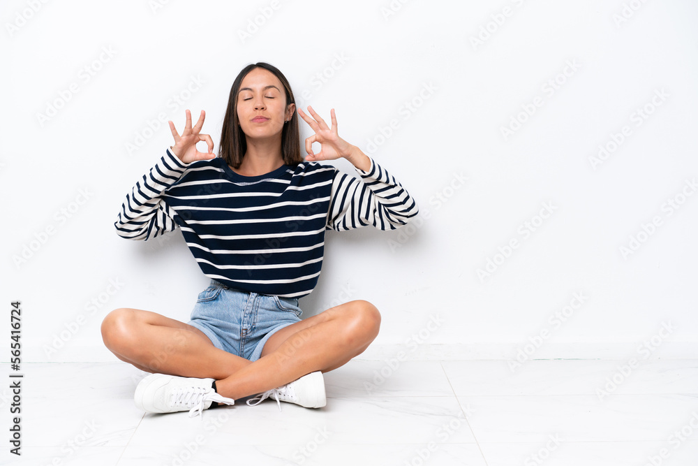 Young caucasian woman sitting on the floor isolated on white background in zen pose Young caucasian woman sitting on the floor isolated on white background in zen pose
