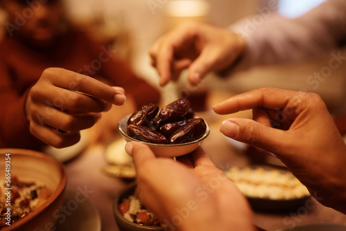 Close up of Middle Eastern family eat date on Ramadan at dining table. photo