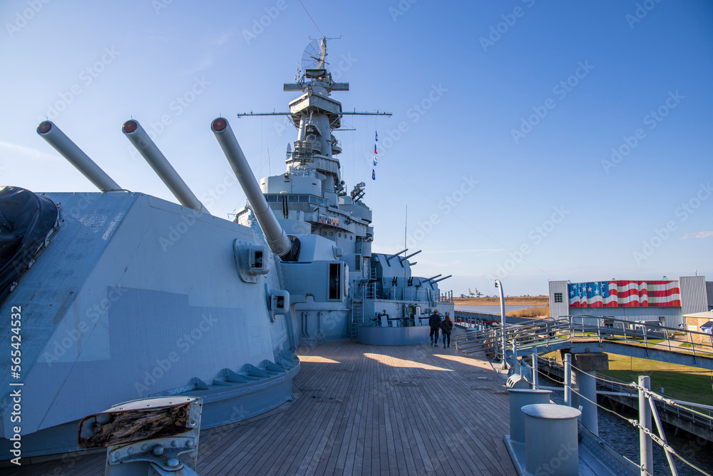 Foto de A man and a woman walking across the wooden deck of the USS