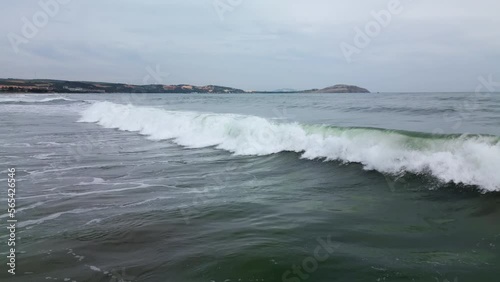 Aerial view wide wild sea beach with waves. Flight on drone over sandy beach and waves crashing on shore. Drone view beautiful seamless never ending footage while turquiose sea waves. Vietnam Asia. 4K