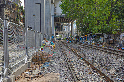 BANGKOK, THAILAND - 12.19.2022: Railway in the city center, garbage, fighting cock cages, huts of homeless lumes occupying garbage collection photo