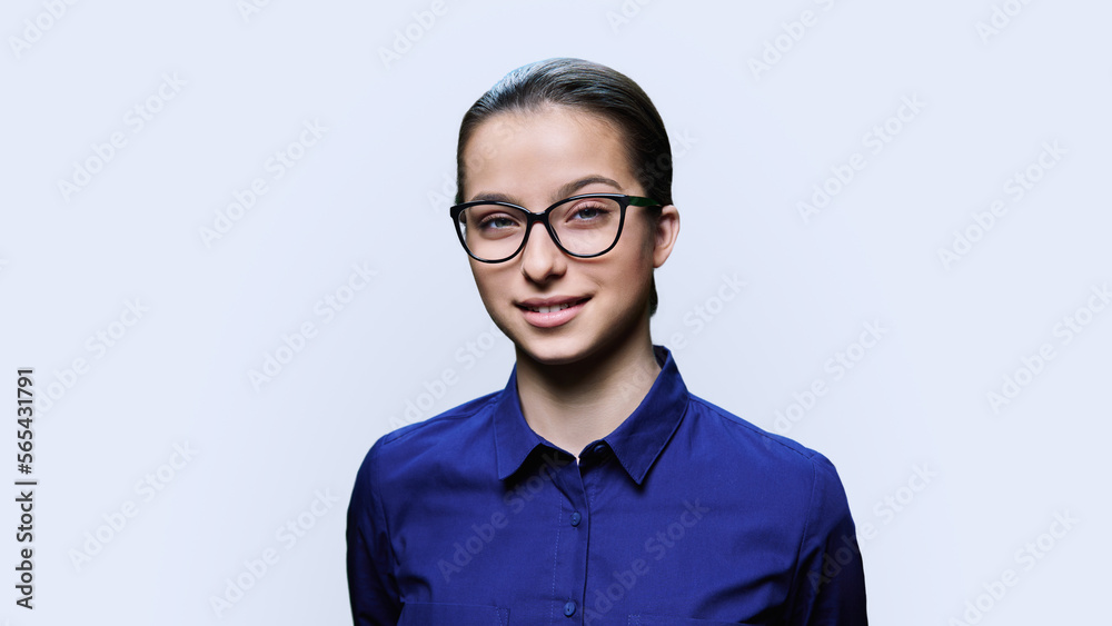 Teenage girl student in glasses looking at camera on white background