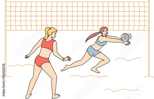 Women in bikini playing volleyball on beach