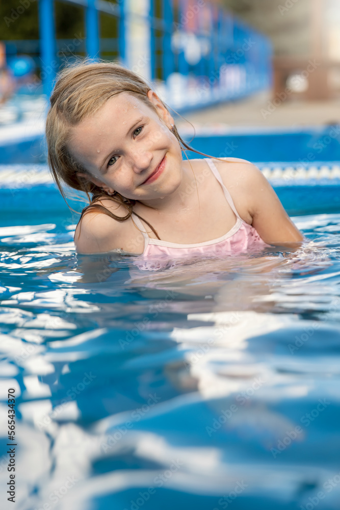Joyful child at edge of swimming pool in summer	