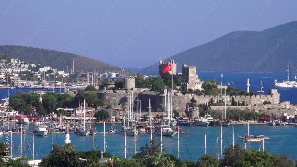 View of Bodrum castle, boats in the sea and waving Turkish flag View of Bodrum castle, boats in the sea and waving Turkish flag