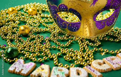 Fotótapéta Mardi Gras King Cake Cookies, Carnival Masks, Gold Beads on Green Background