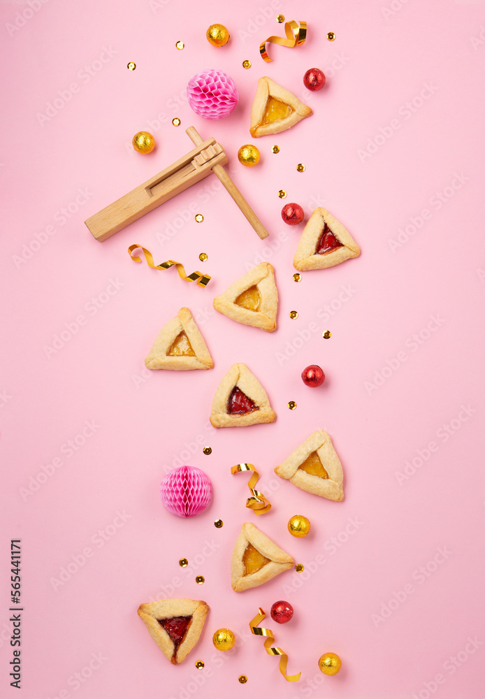 Hamantaschen Cookies, Red Carnival Mask, Noisemaker on Pink Background. Purim Celebration, Jewish Carnival Holiday Concept. Hamantaschen Cookies, Red Carnival Mask, Noisemaker on Pink Background. Purim Celebration, Jewish Carnival Holiday Concept.