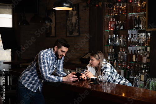 Millennial hipsters husband and wife owners of cafe bar restaurant sitting in the evening after closing talking checking profit, sales calculating order for the next day and resting after a busy day