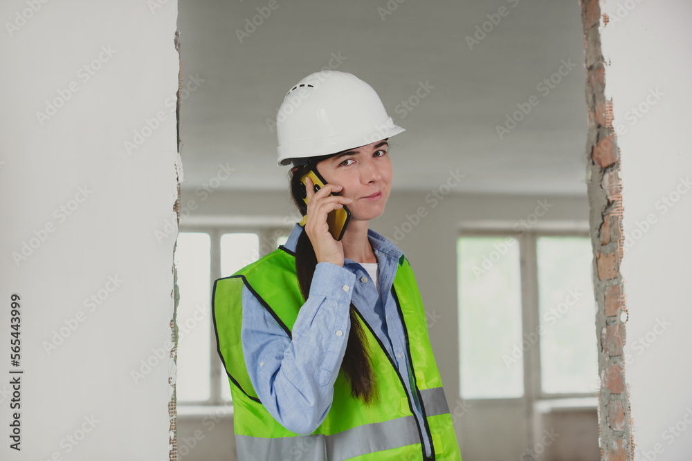 foreman woman consults clients on mobile phone. Inspector or Safety Supervisor in construction site. woman in man construction profession foreman woman consults clients on mobile phone. Inspector or Safety Supervisor in construction site. woman in man construction profession