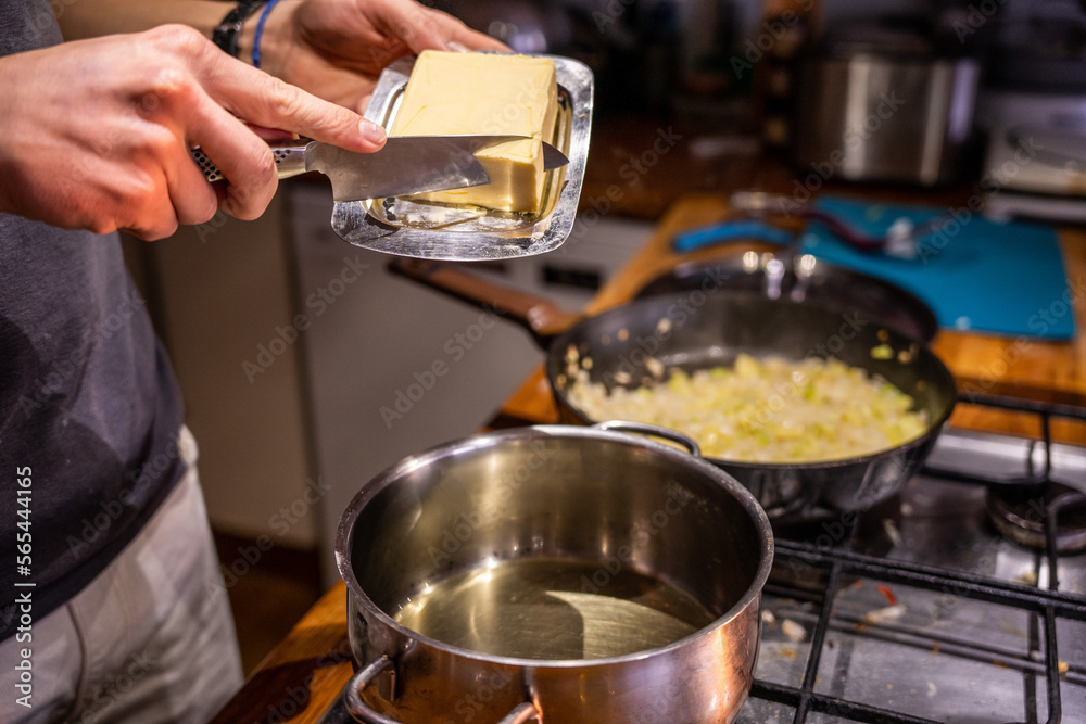 A boy putting butter in a cooking pot. A boy putting butter in a cooking pot.