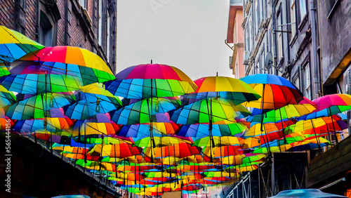 Colorful umbrellas hanging in the air. Colorful umbrellas in the sky. Background colorful street decoration. Street decorated with colored umbrellas