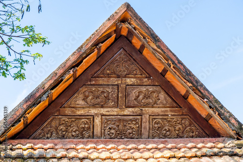 Carving wood gable roof on a resort hotel in India, Alappuzha, Kerala. Wooden roof structure, traditional indian style. Eco design concept. Hight quality photo.  photo