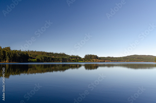 Mountain lake with calm water like a mirror where the trees of the forest are reflected.
