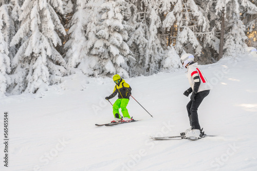Winter family vacation concept with mother and child enjoying skiing.