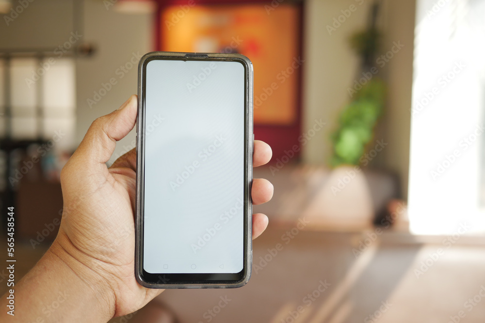 young man hand using smart phone with white screen at cafe 