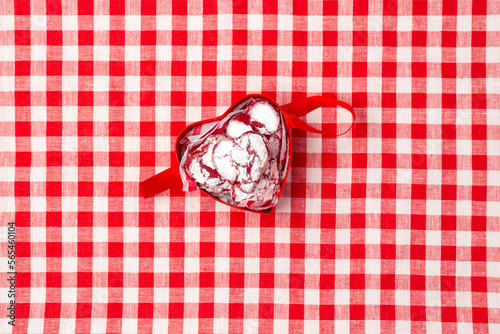 red box in the shape of a heart with cookies for valentine's day on a red checkerd tablecloth
