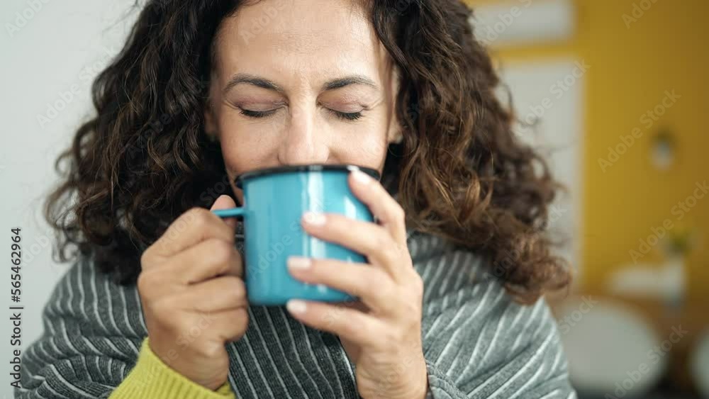 Middle age hispanic woman drinking coffee standing at street Middle age hispanic woman drinking coffee standing at street