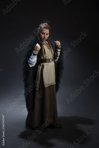 An authoritative, self-confident woman in a Viking-style fantasy costume. skirt with shirt and long fur cape, Scandinavian style